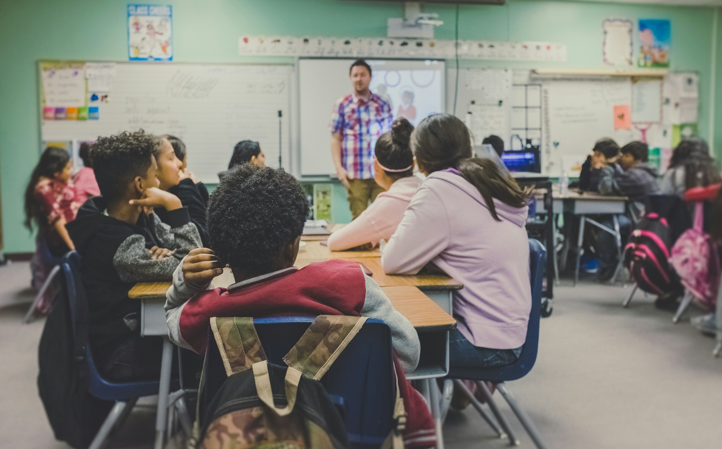 Teacher leading a classroom of students in an active lesson
